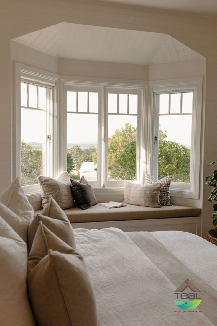 Angled bay window with a built-in bench seat and cushions in a bright bedroom