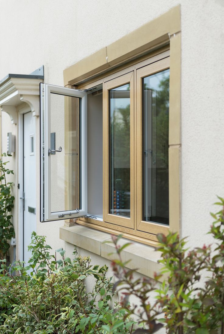 Side-hinged casement window swung open outward on the exterior of a light stucco home