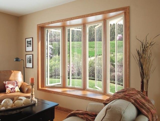 Curved wood-framed bow window with four panels looking out over a green lawn