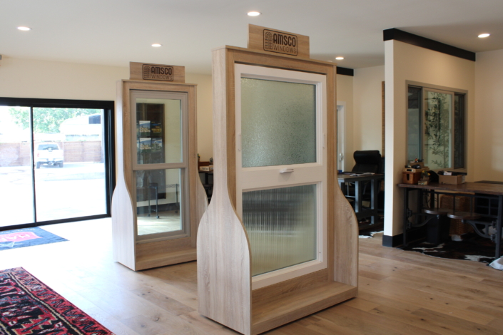 Two Amsco window display units on showroom stands, one a double-hung with textured privacy glass