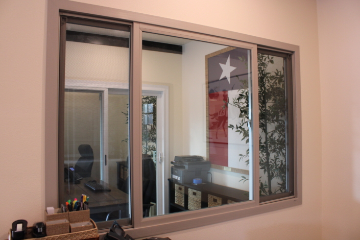 Clay-framed horizontal slider window finished flush against an interior wall