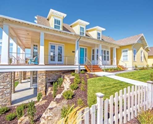 Yellow Austin home exterior showcasing energy efficient window replacement Austin, TX durability