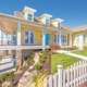 Yellow Austin home exterior showcasing energy efficient window replacement Austin, TX durability