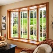 Bright living room featuring large energy-efficient bay windows with natural outdoor views