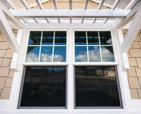Window replacement in Austin, TX featuring energy-efficient white-framed windows on a residential home
