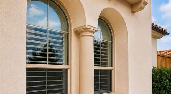 Window replacement in Cedar Park, TX featuring energy-efficient arched windows on a stucco home