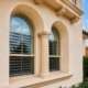 Window replacement in Cedar Park, TX featuring energy-efficient arched windows on a stucco home